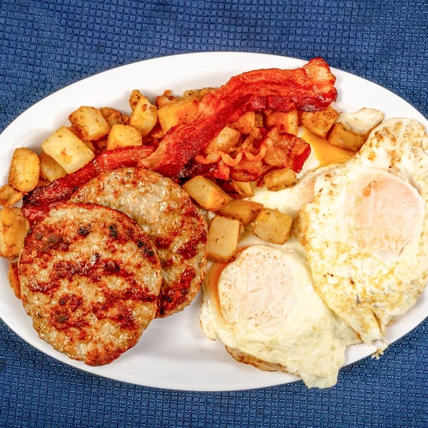 A Sunnyside Diner breakfast plate with sausage patties, bacon, fried eggs, and home fries.