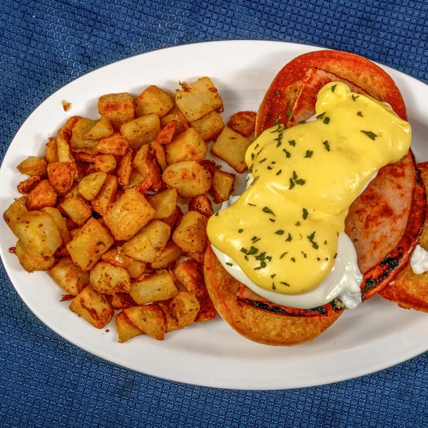 Sunnyside Diner's Eggs Benedict with hollandaise sauce and a side of crispy home fries.