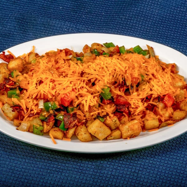 A Sunnyside Diner breakfast skillet with crispy potatoes, bacon, peppers, onions, and melted cheddar cheese.