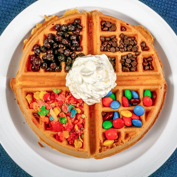 A Sunnyside Diner waffle with blueberries, chocolate chips, Fruity Pebbles, M&M's, and whipped cream.